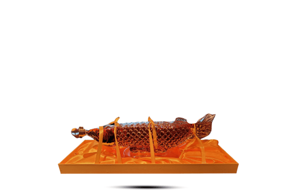 An orange translucent fish sculpture or displayed on a matching orange rectangular base against a plain white background.